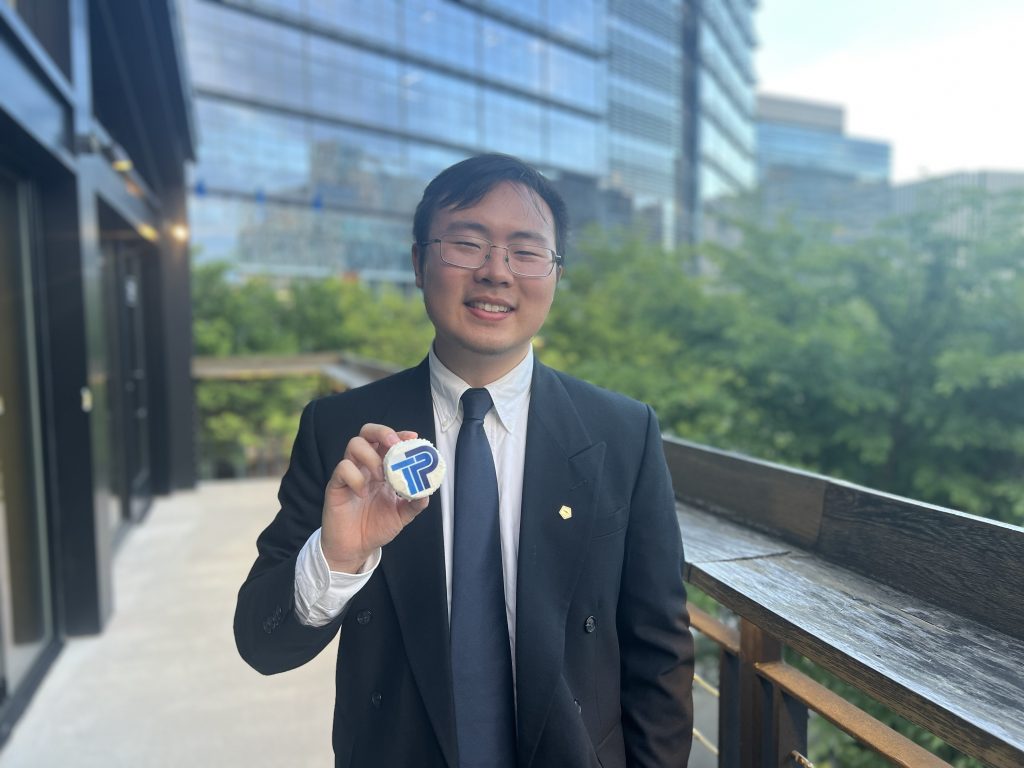Daniel Xue holding a cupcake